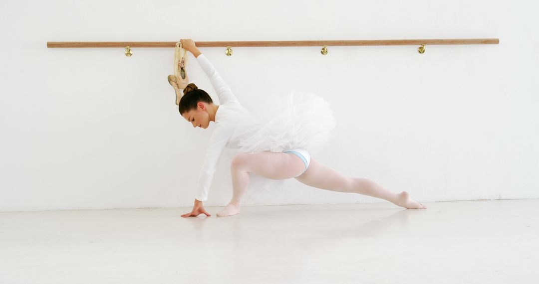 Graceful Ballerina Practicing at Barre in Bright Studio