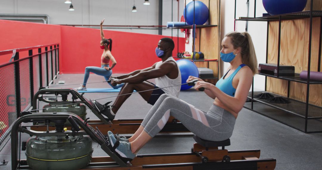 Diverse Group Exercising in Gym with Face Masks Using Rowing Machines - Free Images, Stock Photos and Pictures on Pikwizard.com