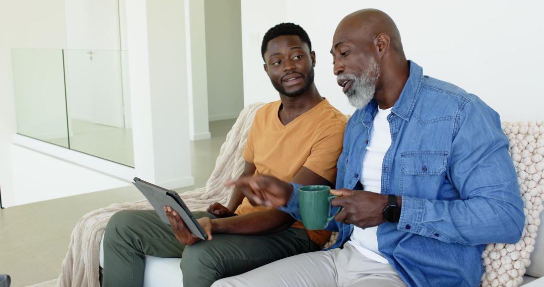 Father and Son Sharing Technology Bonding Over Home Conversation