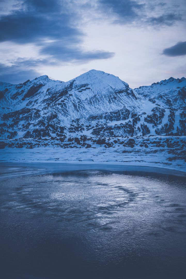 Serene Winter Landscape with Snow-Covered Mountains and Icy Lake - Free Images, Stock Photos and Pictures on Pikwizard.com