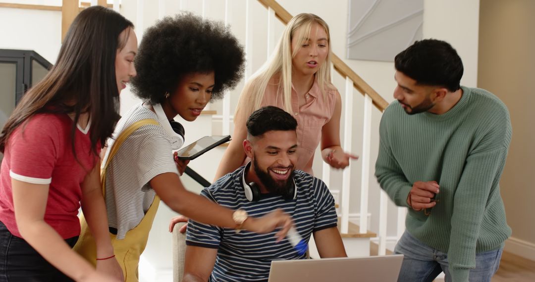 Diverse Team Discussing Project Around Laptop At Home