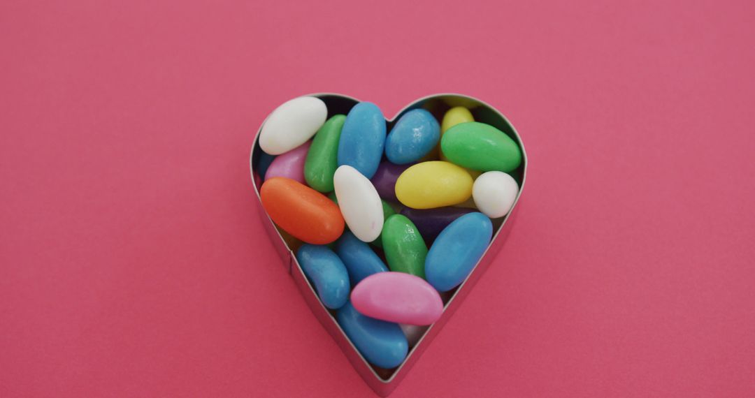 Multicolored Candy in Heart Shaped Container on Pink Background - Free Images, Stock Photos and Pictures on Pikwizard.com