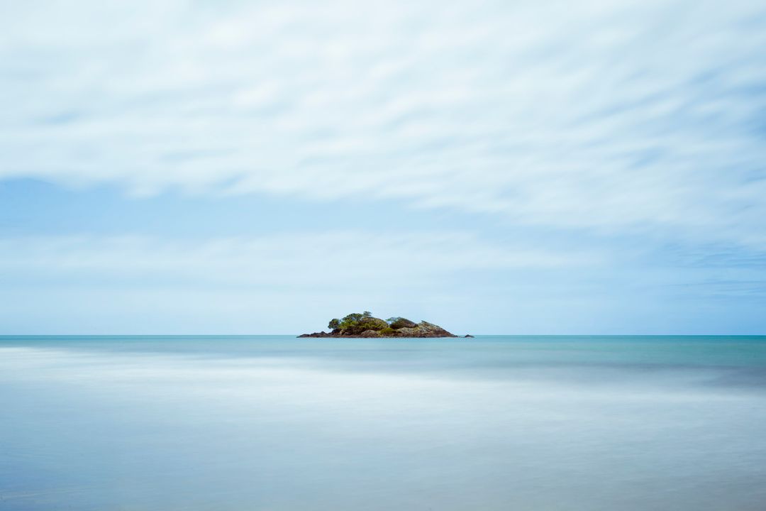 Remote Island in Calm Ocean on Cloudy Day with Serene Horizon - Free Images, Stock Photos and Pictures on Pikwizard.com