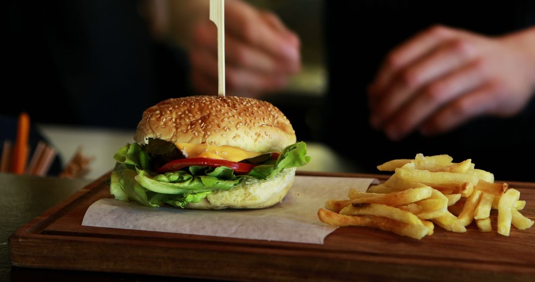 Classic Cheeseburger with Lettuce, Tomato, and French Fries on Wooden Board - Free Images, Stock Photos and Pictures on Pikwizard.com