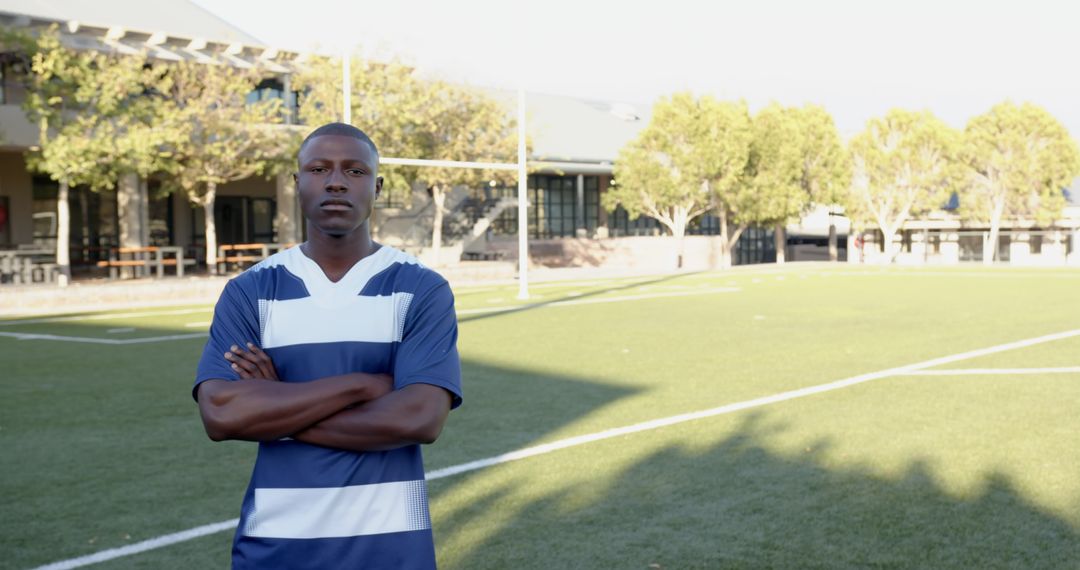 Confident Athlete Posing on Soccer Field in Sunlight