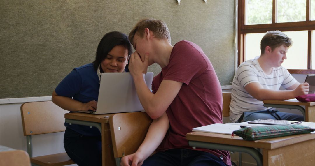 Teen Students Whispering During Lesson in Classroom - Free Images, Stock Photos and Pictures on Pikwizard.com