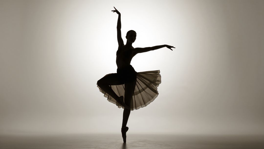 Ballerina silhouette en pointe in flowing tutu with halo backlight, dramatic studio