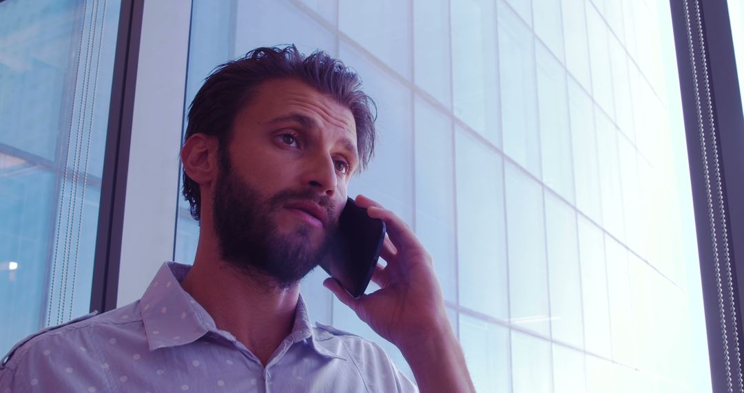 Businessman Discussing Vital Matter on Phone Near Office Window