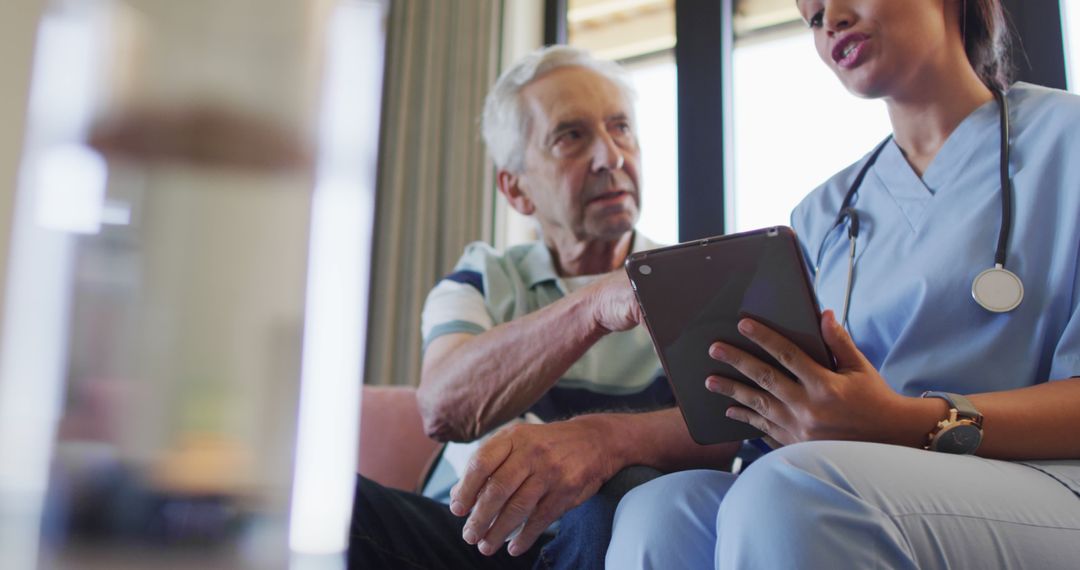 Senior Man Discussing Medical Records with Nurse Using Digital Tablet - Free Images, Stock Photos and Pictures on Pikwizard.com