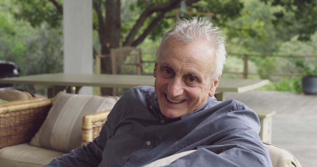 Smiling Elderly Man Relaxing on Patio with Greenery in Background - Free Images, Stock Photos and Pictures on Pikwizard.com