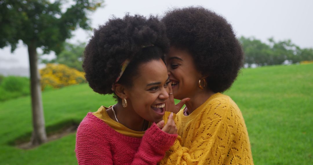 Joyful Sisters Embracing Outdoors in Colorful Sweaters