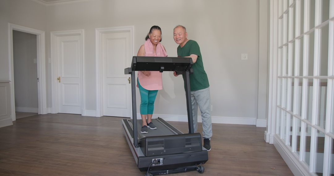 Senior Couple Enjoying Treadmill Exercise at Home Together