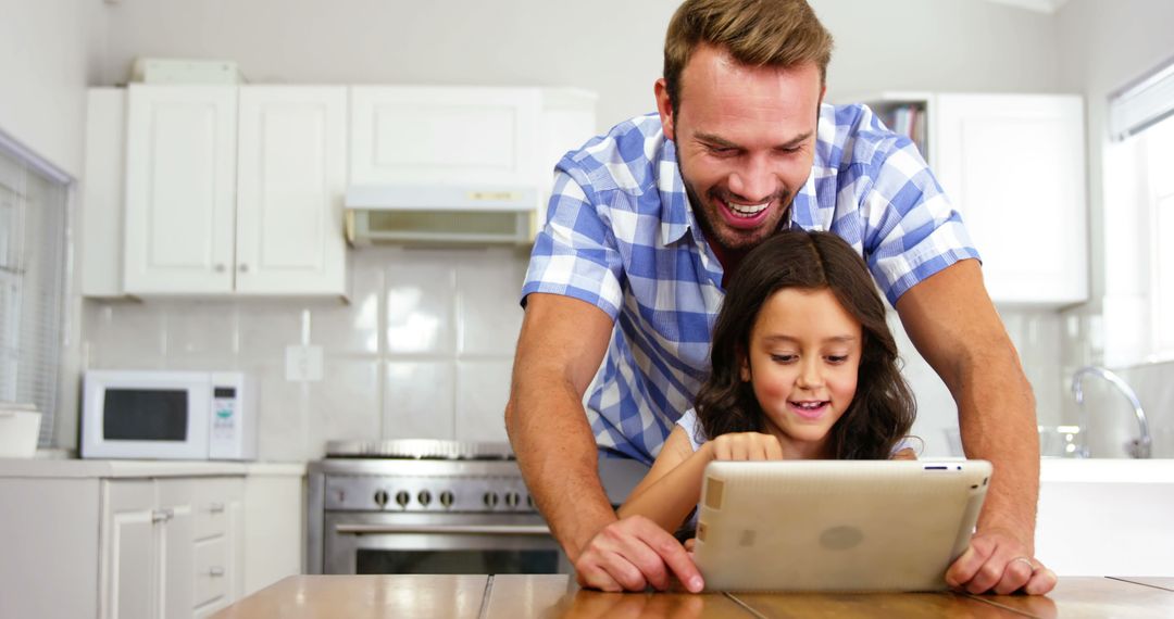 Father and Daughter Using Digital Tablet Together in Kitchen - Free Images, Stock Photos and Pictures on Pikwizard.com