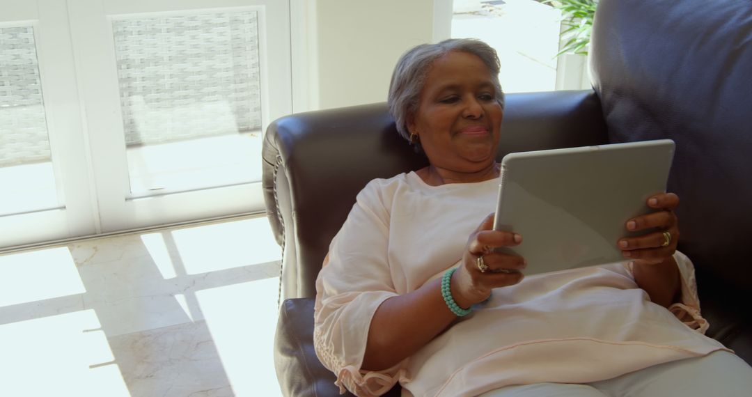 Senior Woman Relaxing on Sofa Using Tablet at Home - Free Images, Stock Photos and Pictures on Pikwizard.com