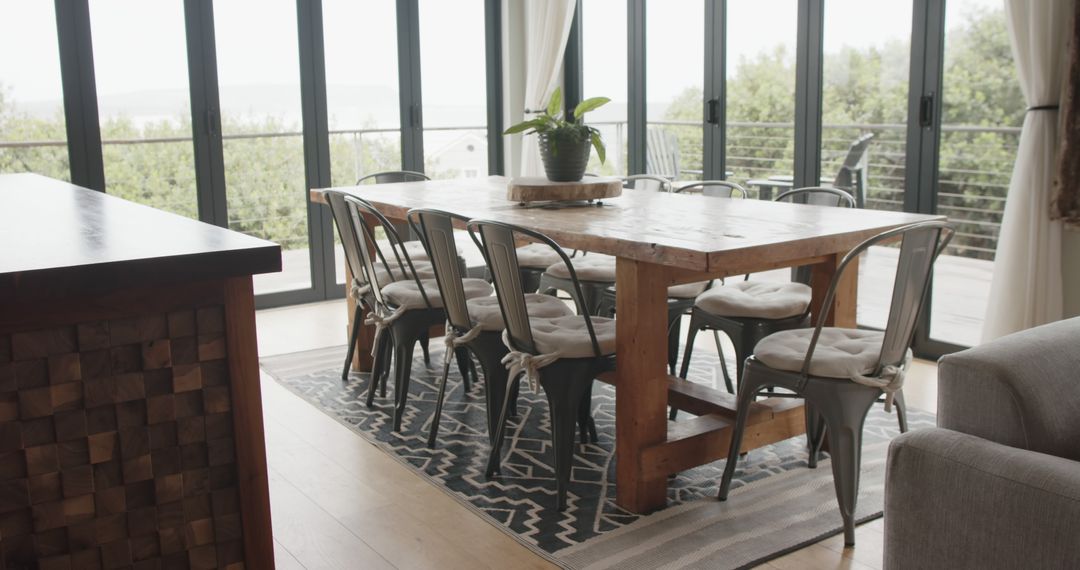 Cozy dining room with large windows and wooden table - Free Images, Stock Photos and Pictures on Pikwizard.com