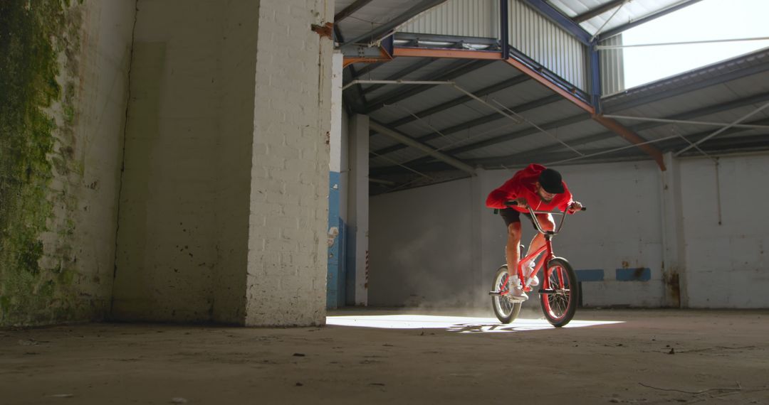 Young Man Riding BMX Bike in Abandoned Warehouse - Free Images, Stock Photos and Pictures on Pikwizard.com