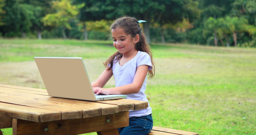 Young Girl Engaging with Laptop in Outdoor Setting for Online Learning - Free Images, Stock Photos and Pictures on Pikwizard.com