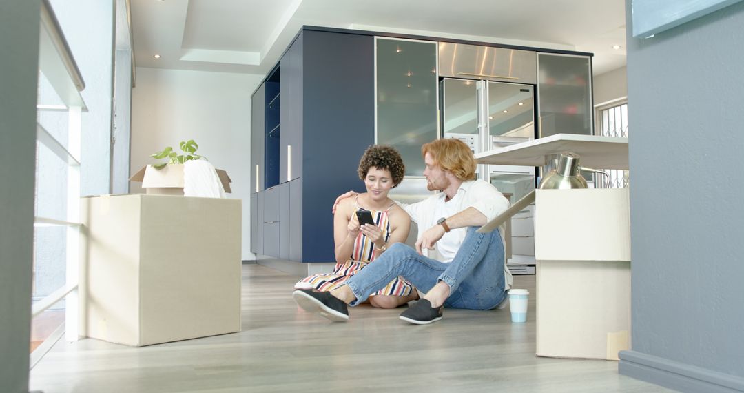 Happy Couple Embracing and Relaxing with Smartphone During Move