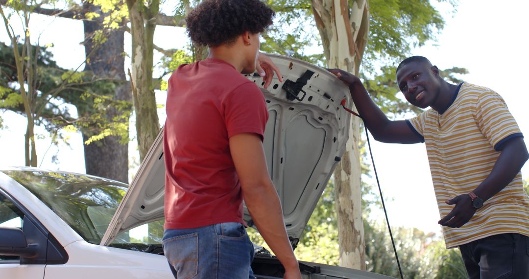 Young Men Checking Car Engine in Shady Driveway Scene