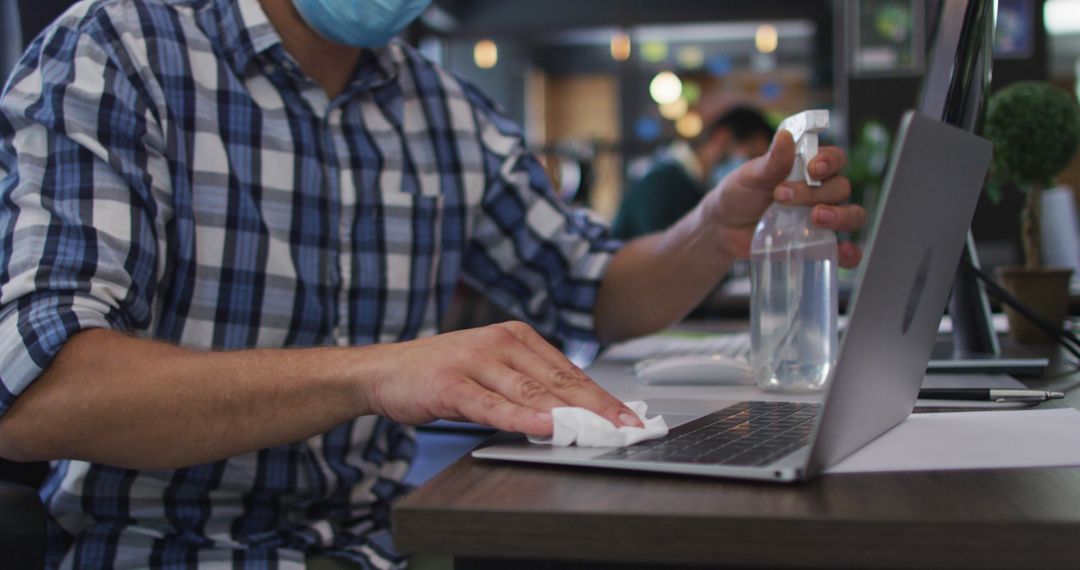 Employee Sanitizing Laptop with Disinfectant Wipe in Office - Free Images, Stock Photos and Pictures on Pikwizard.com