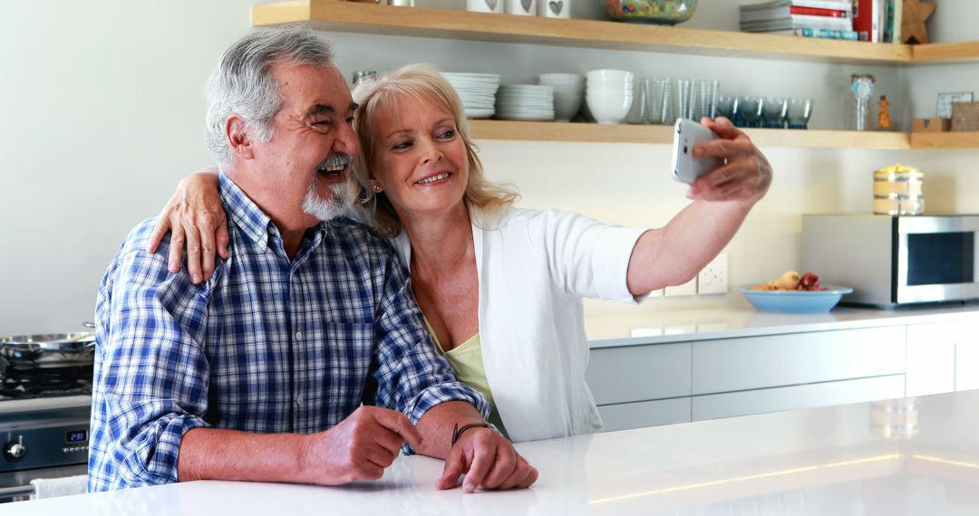 Smiling Senior Couple Taking Selfie in Modern Kitchen - Free Images, Stock Photos and Pictures on Pikwizard.com