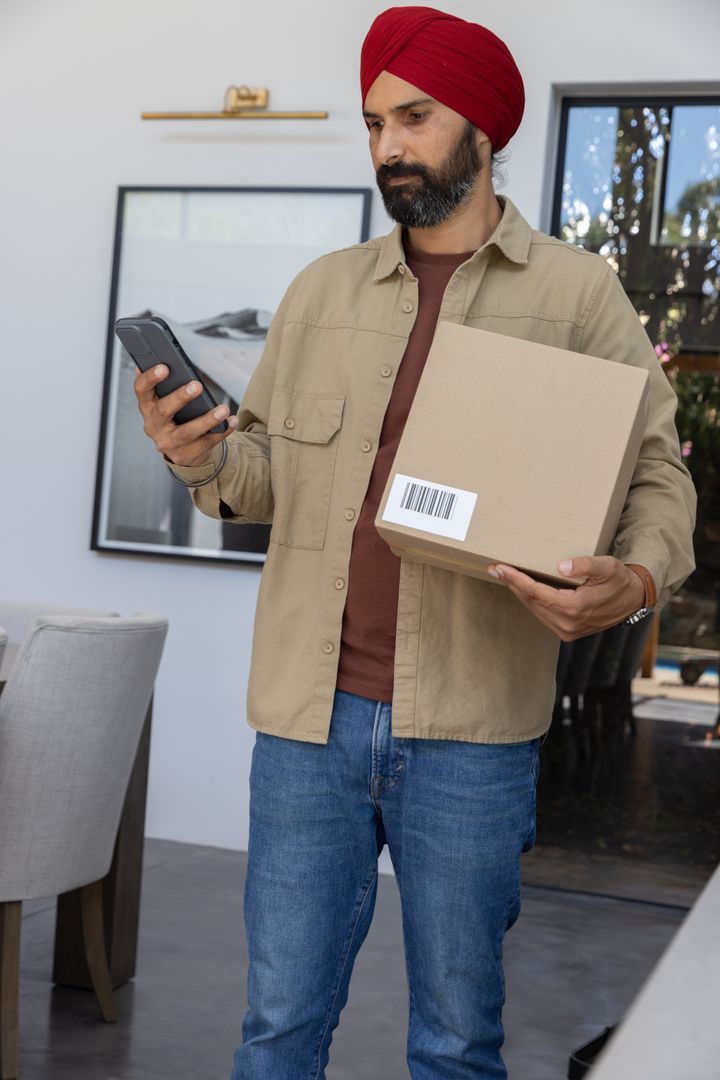 Indian Man With Turban Using Device to Scan Package Indoors
