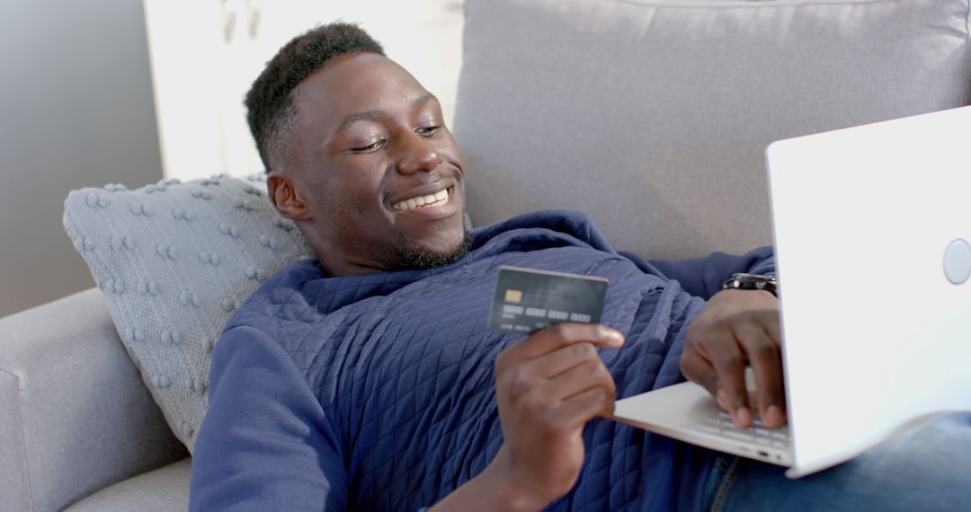 Smiling Man Shopping Online While Holding Credit Card - Free Images, Stock Photos and Pictures on Pikwizard.com