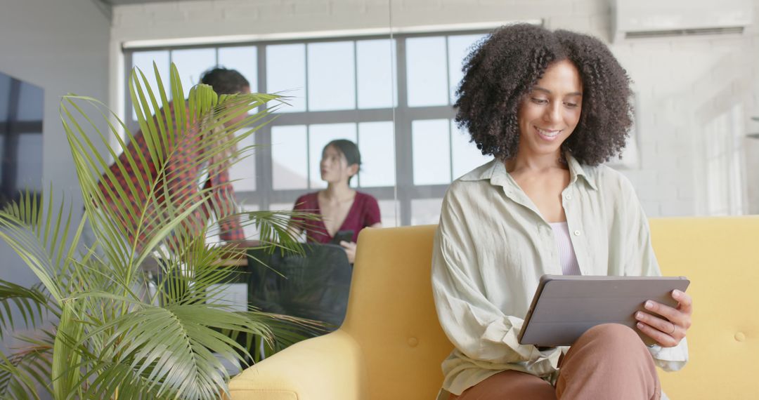 Businesswoman Engaging with Tablet in Collaborative Office Space