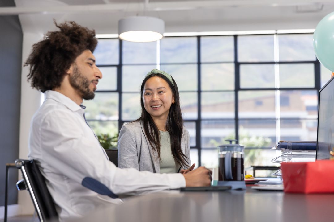 Diverse Coworkers Engaging in Office Meeting with Modern Workspace
