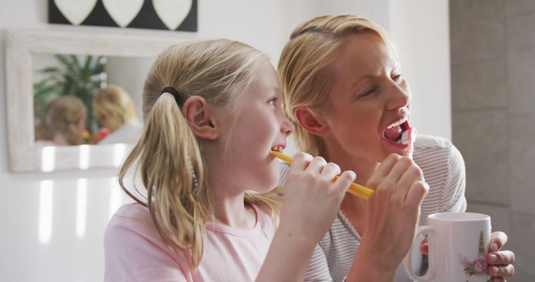 Happy Caucasian Mother and Daughter Brushing Teeth Together in Bathroom - Free Images, Stock Photos and Pictures on Pikwizard.com