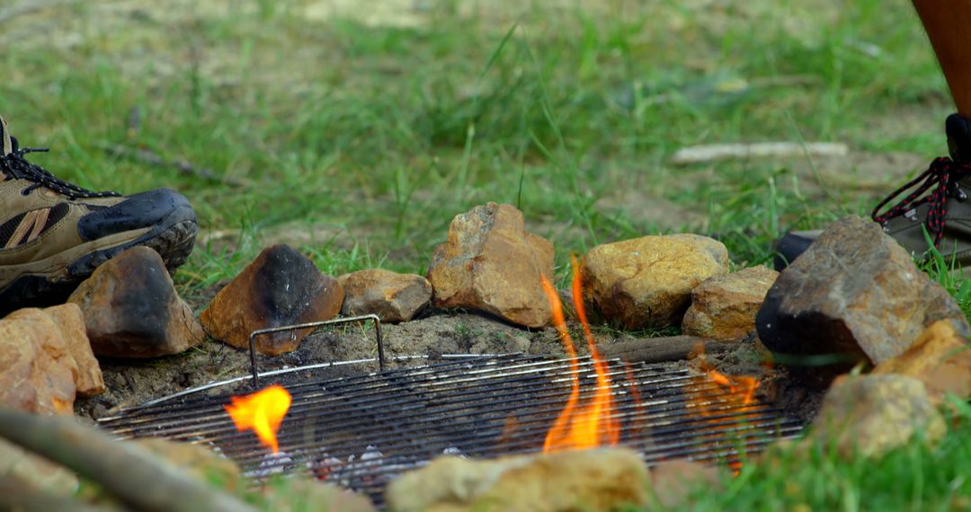 People Sitting Around Campfire With Grilling Rack, Camping and Outdoor Adventures - Free Images, Stock Photos and Pictures on Pikwizard.com