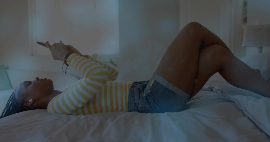 Woman Relaxing with Smartphone on Bed at Home