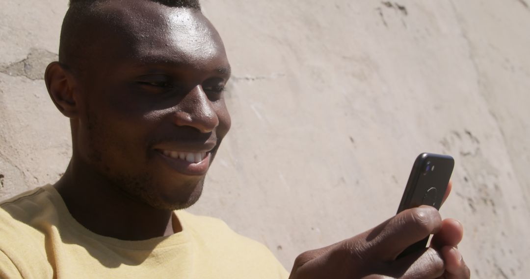 Smiling African American Young Man Texting with Smartphone - Free Images, Stock Photos and Pictures on Pikwizard.com