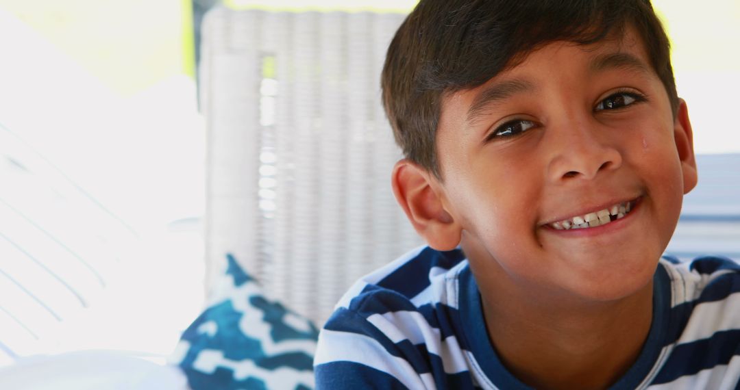 A young boy with a cheerful smile is pictured indoors, with copy space - Free Images, Stock Photos and Pictures on Pikwizard.com