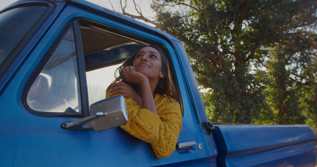 Smiling Young Woman Daydreaming in Blue Pickup Truck - Free Images, Stock Photos and Pictures on Pikwizard.com