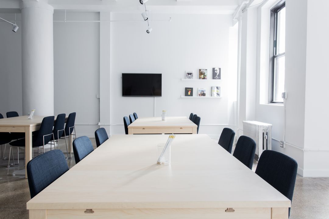 Minimalist Conference Room with Wooden Tables and Black Chairs