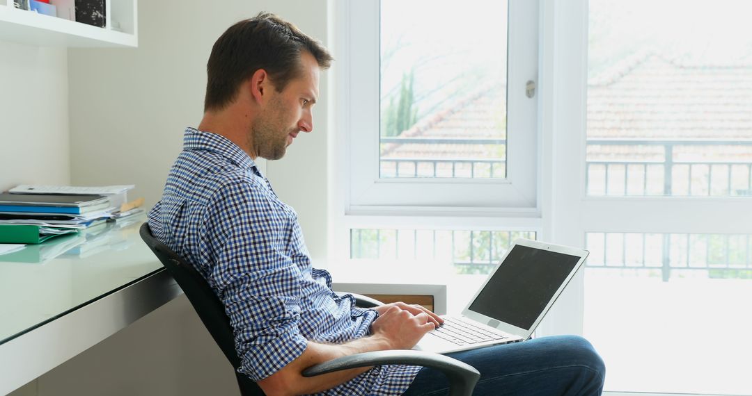 Man Working From Home on Laptop in Bright Office - Free Images, Stock Photos and Pictures on Pikwizard.com