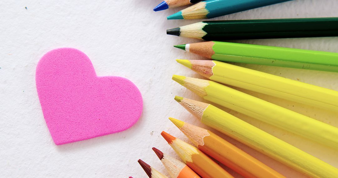 A heart sponge and colored pencils evoke a creative, educational vibe on a white space. - Free Images, Stock Photos and Pictures on Pikwizard.com