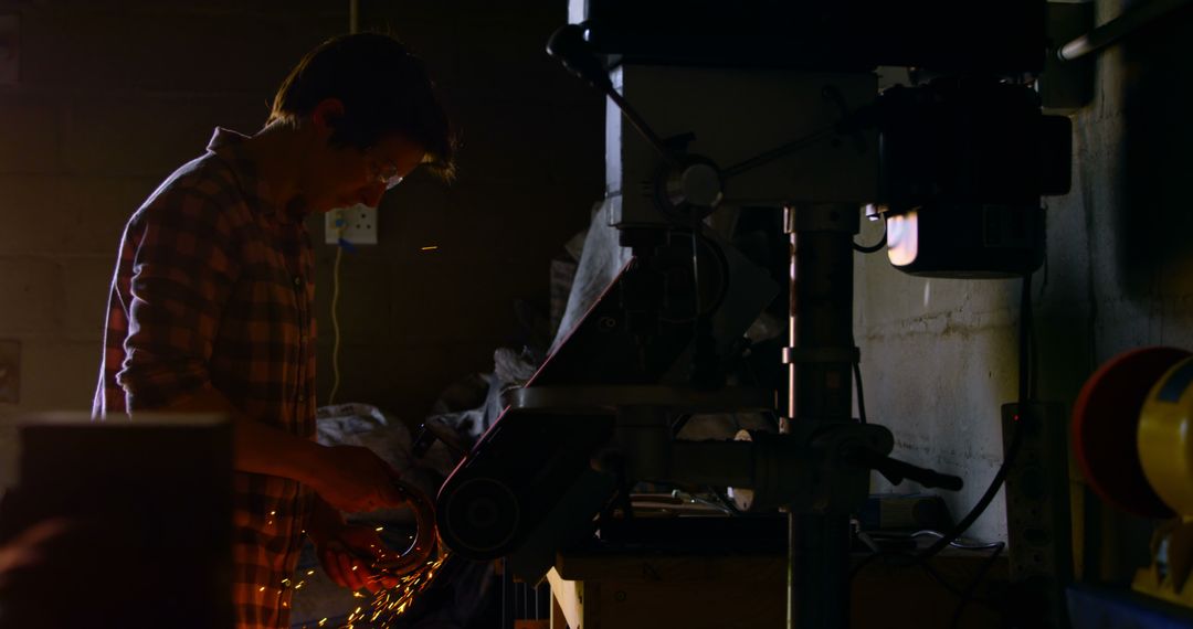 Silhouette of Young Male Engineer Working in Workshop with Metal Grinder - Free Images, Stock Photos and Pictures on Pikwizard.com