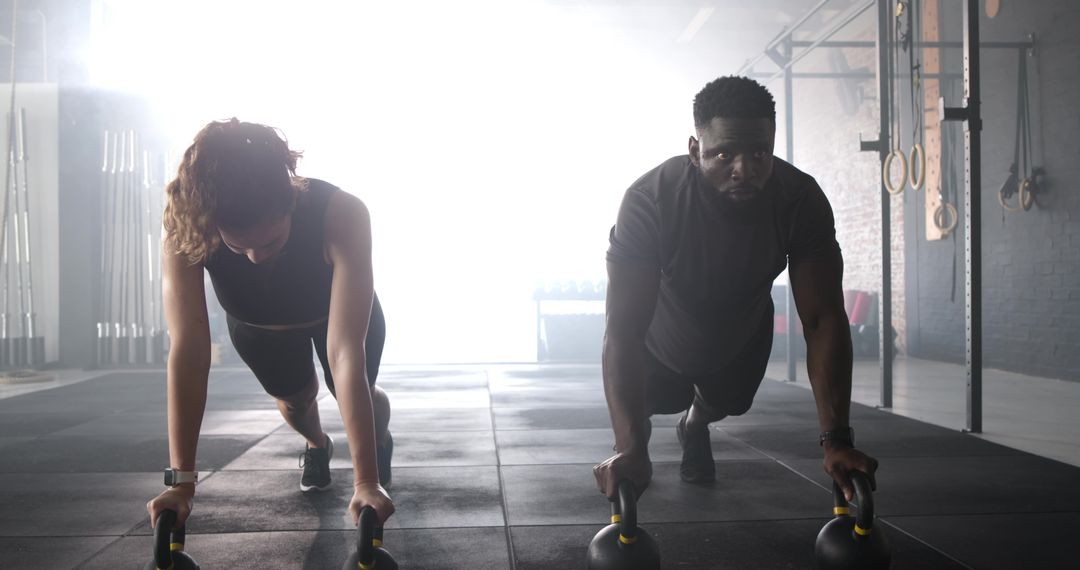Diverse Athletes Performing Kettlebell Push-ups in Gym