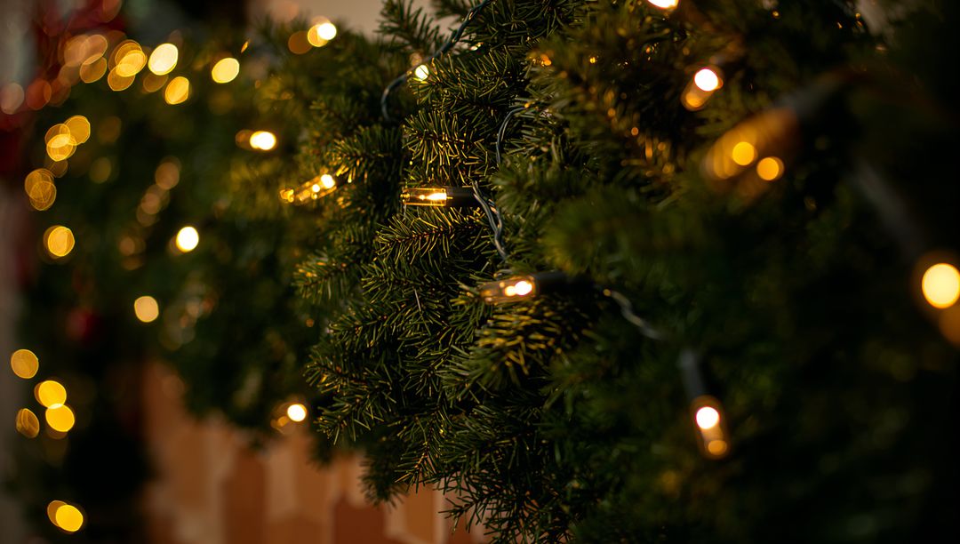 Warm White String Lights on Evergreen Garland with Soft Bokeh Glow for Holiday Decor
