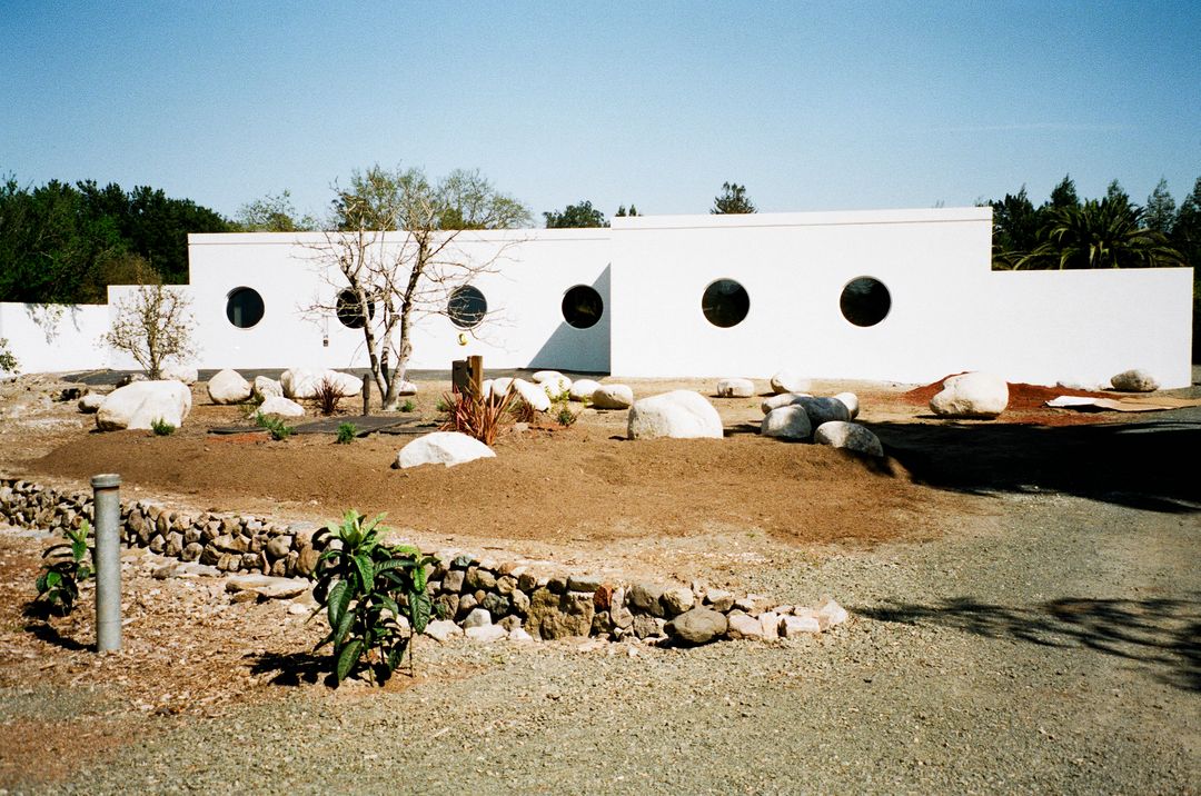 Modern White Building with Circular Windows and Desert Landscaping - Free Images, Stock Photos and Pictures on Pikwizard.com