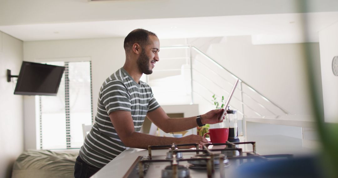 Smiling Man Using Tablet in Modern Kitchen