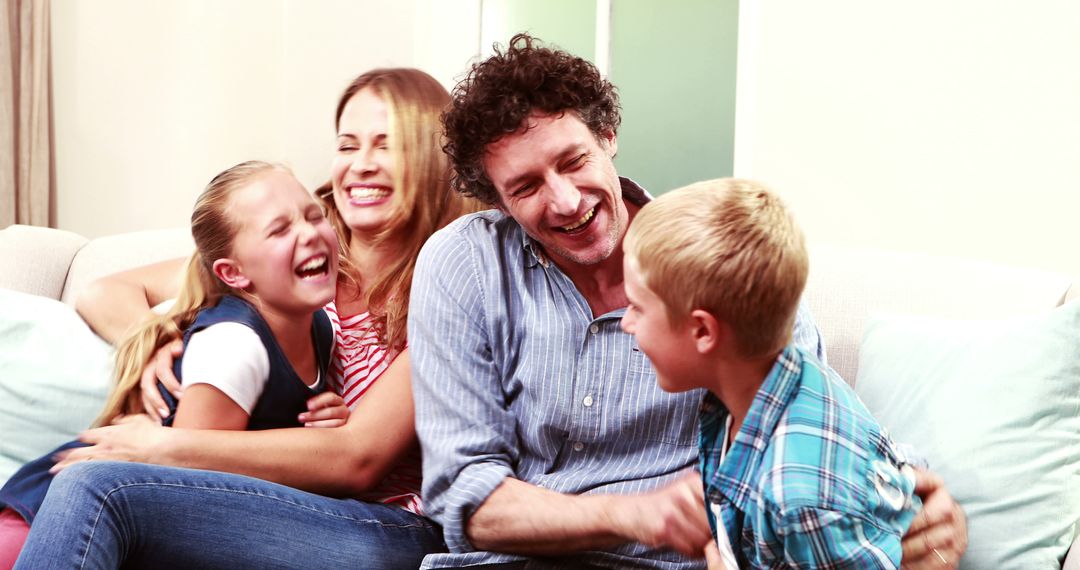 Happy Family Laughing Together on Couch at Home - Free Images, Stock Photos and Pictures on Pikwizard.com