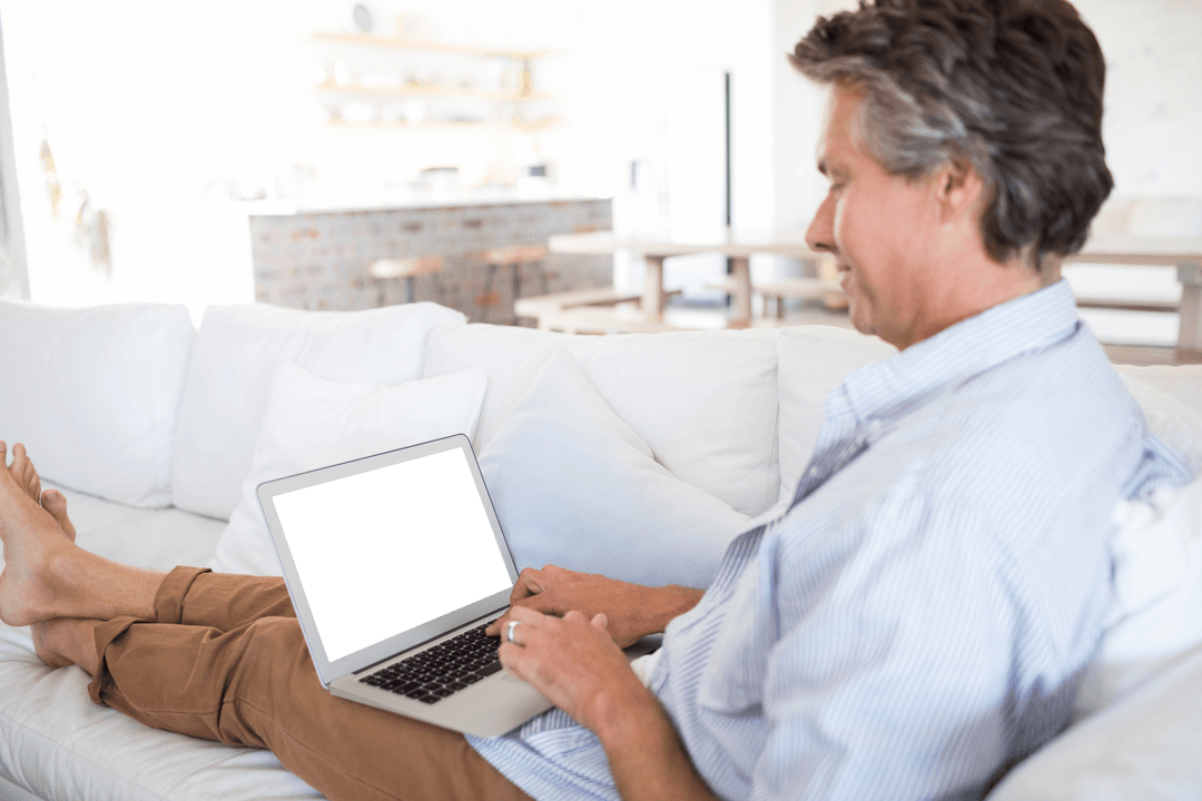 Smiling Middle-Aged Man Relaxing with Laptop on Couch