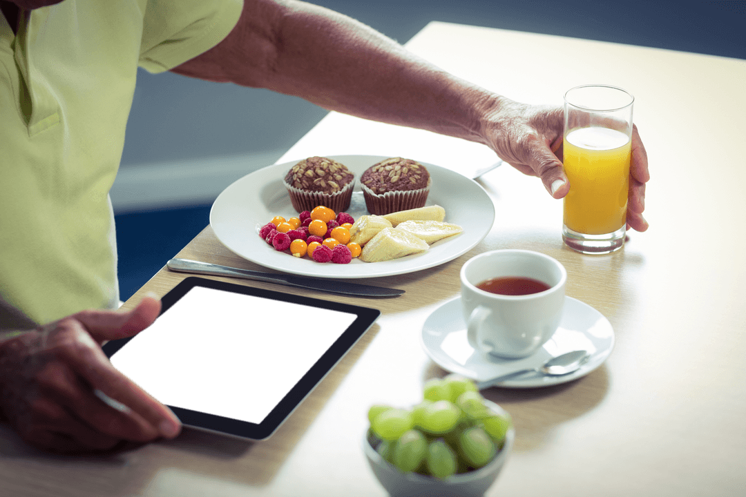 Senior Man Enjoying Transparent Breakfast with Tablet