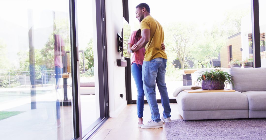 Couple Embracing and Looking Outside Near Large Windows in Modern Living Room - Free Images, Stock Photos and Pictures on Pikwizard.com