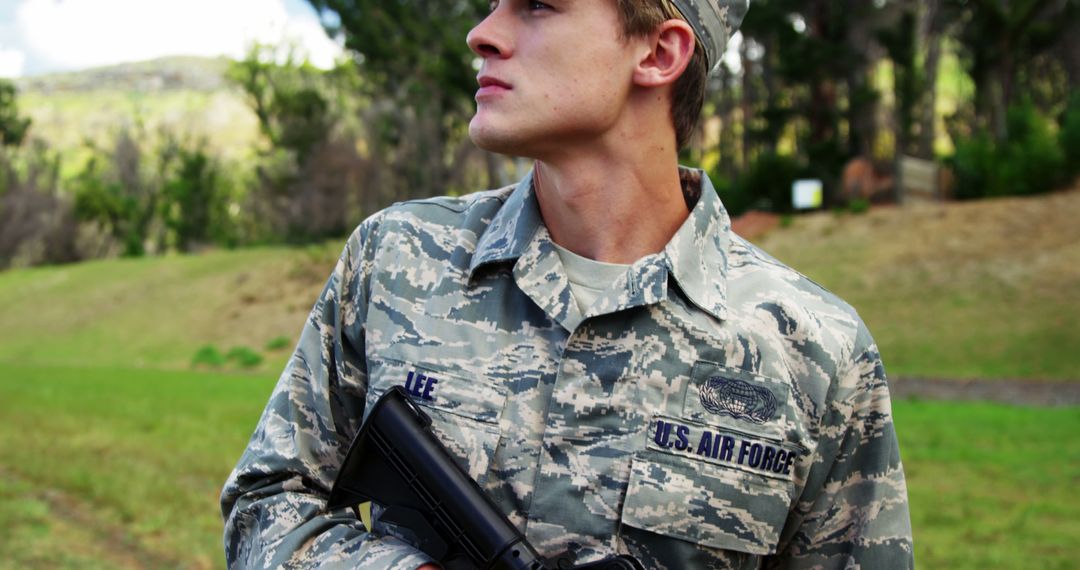 Young Male Soldier Standing Outdoors in Uniform Holding Gun - Free Images, Stock Photos and Pictures on Pikwizard.com