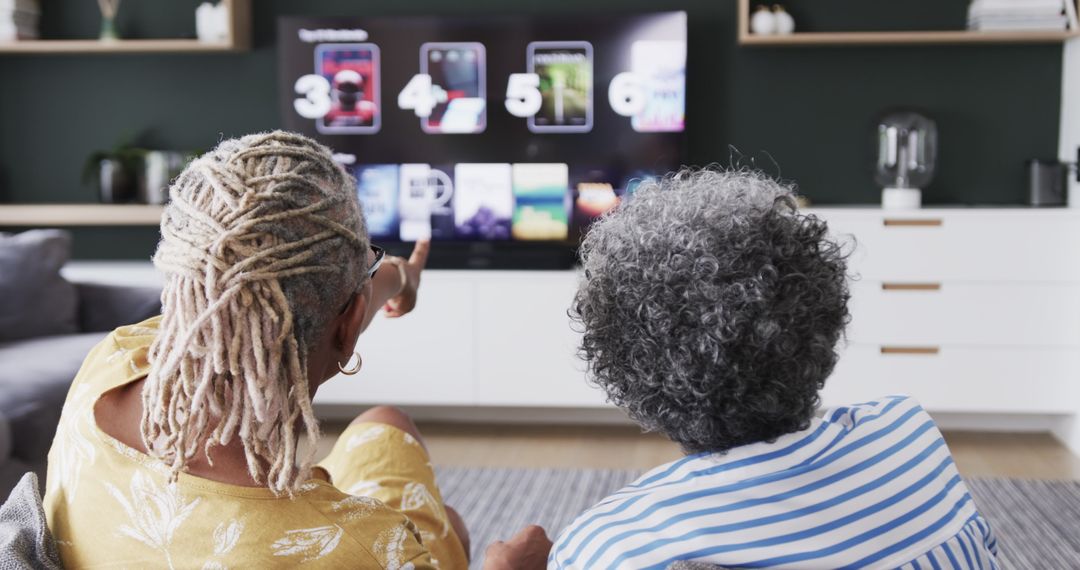 Senior Friends Choosing TV Show Together in Living Room