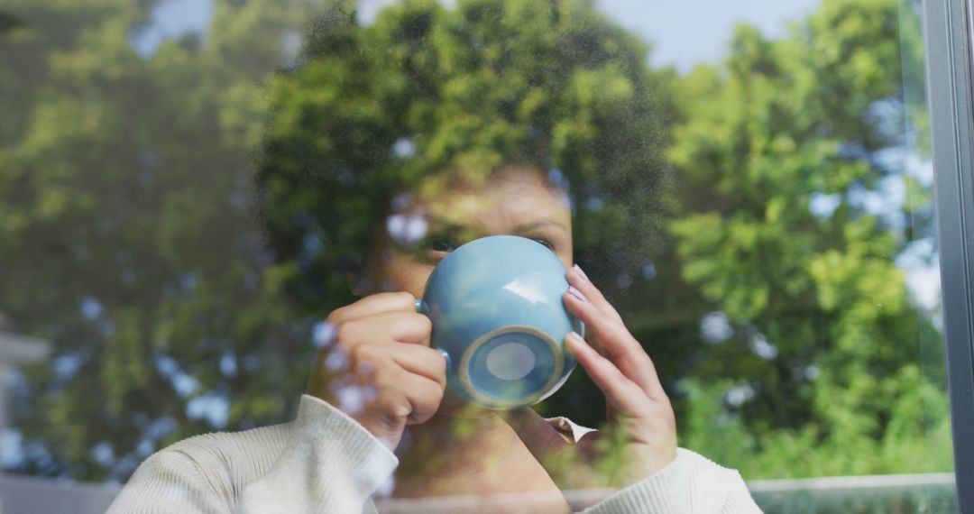 Woman Enjoying Morning Coffee by Window, Green Landscape Reflected on Glass - Free Images, Stock Photos and Pictures on Pikwizard.com